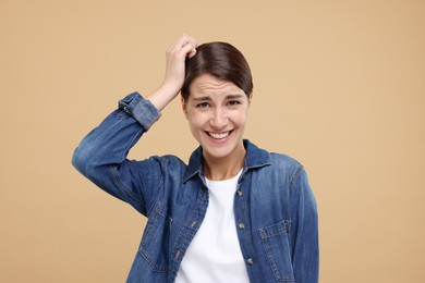 Photo of Portrait of embarrassed young woman on beige background
