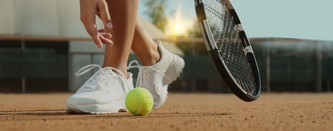 Image of Sportswoman playing tennis at court on sunny day, closeup. Banner design