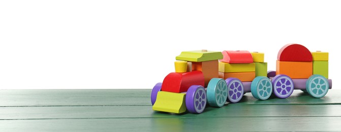 Photo of Colorful wooden train on green table against white background, space for text. Children's toy