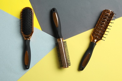 Photo of Set of hair brushes on color background, flat lay