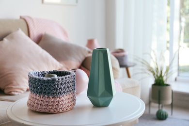 Photo of Side table with beautiful interior elements in living room. Space for text