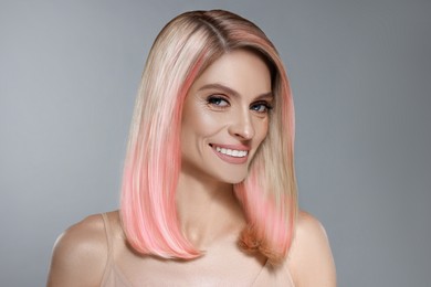 Image of Hair styling. Gorgeous woman with colorful hair on grey background