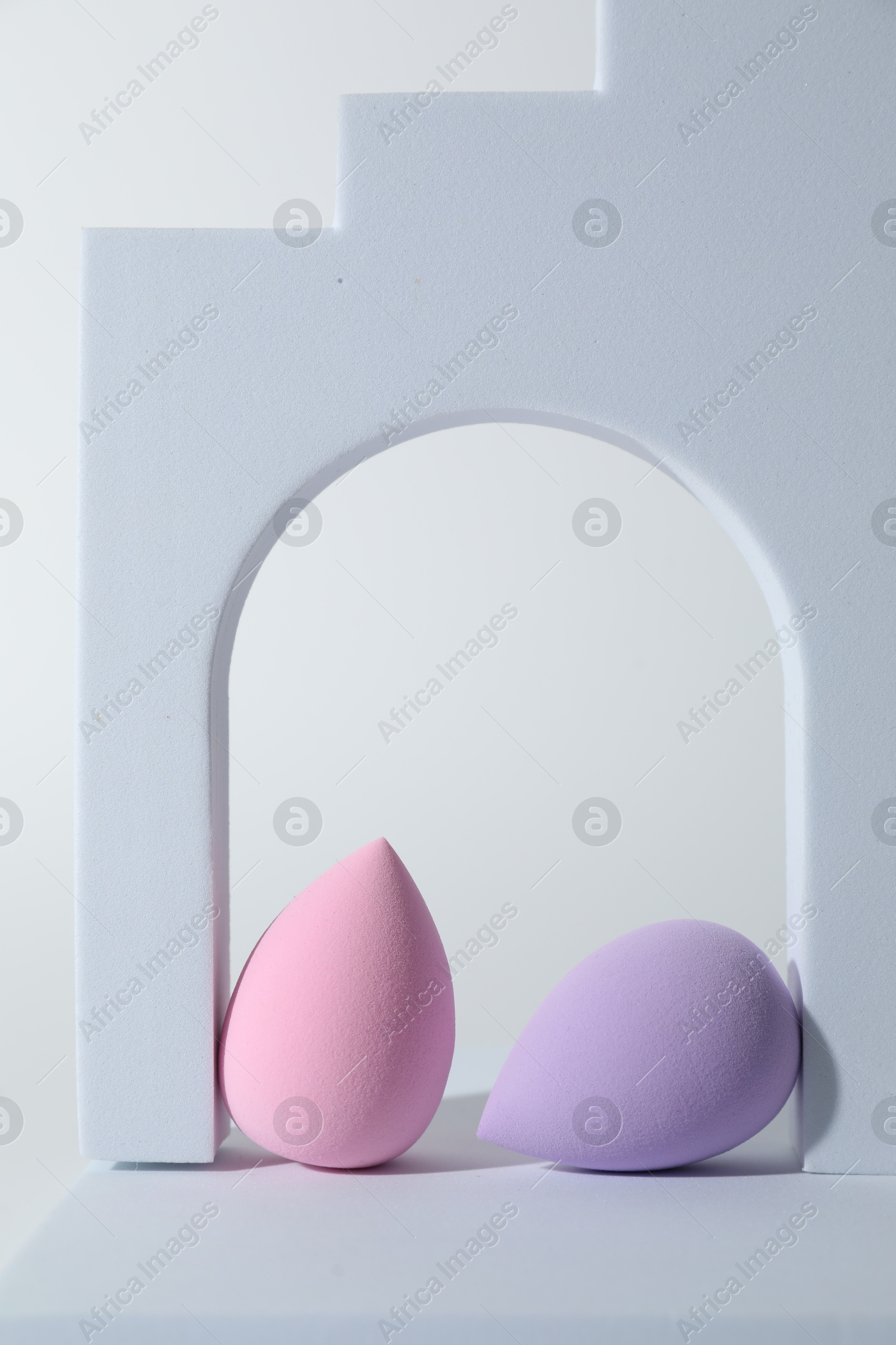 Photo of Stylish presentation of makeup sponges on white background