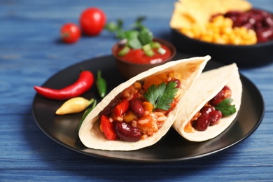 Photo of Chili con carne served with tortilla on table