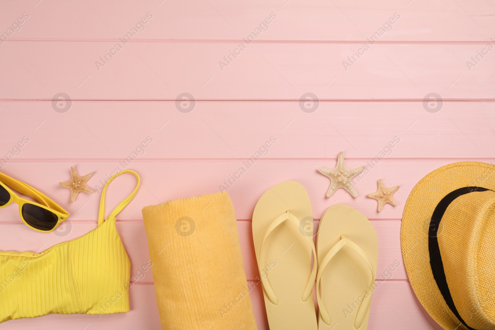 Photo of Flat lay composition with beach objects on pink wooden background, space for text