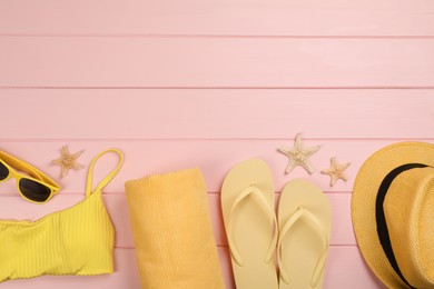 Flat lay composition with beach objects on pink wooden background, space for text