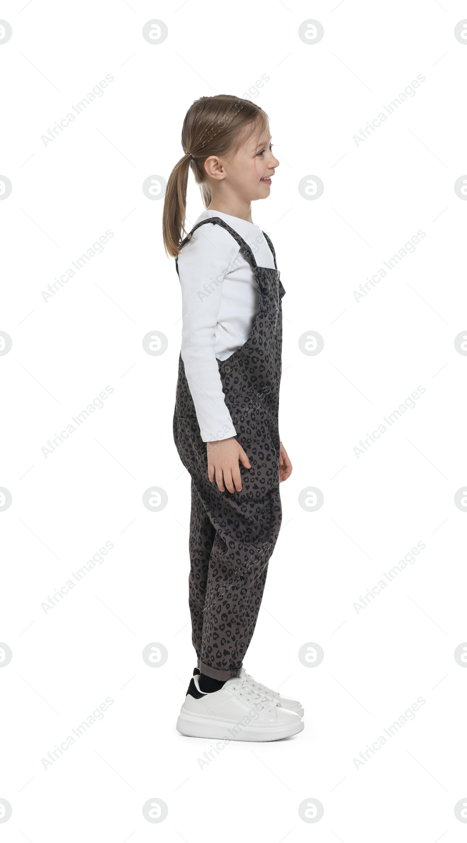 Photo of Cute girl in stylish overall on white background