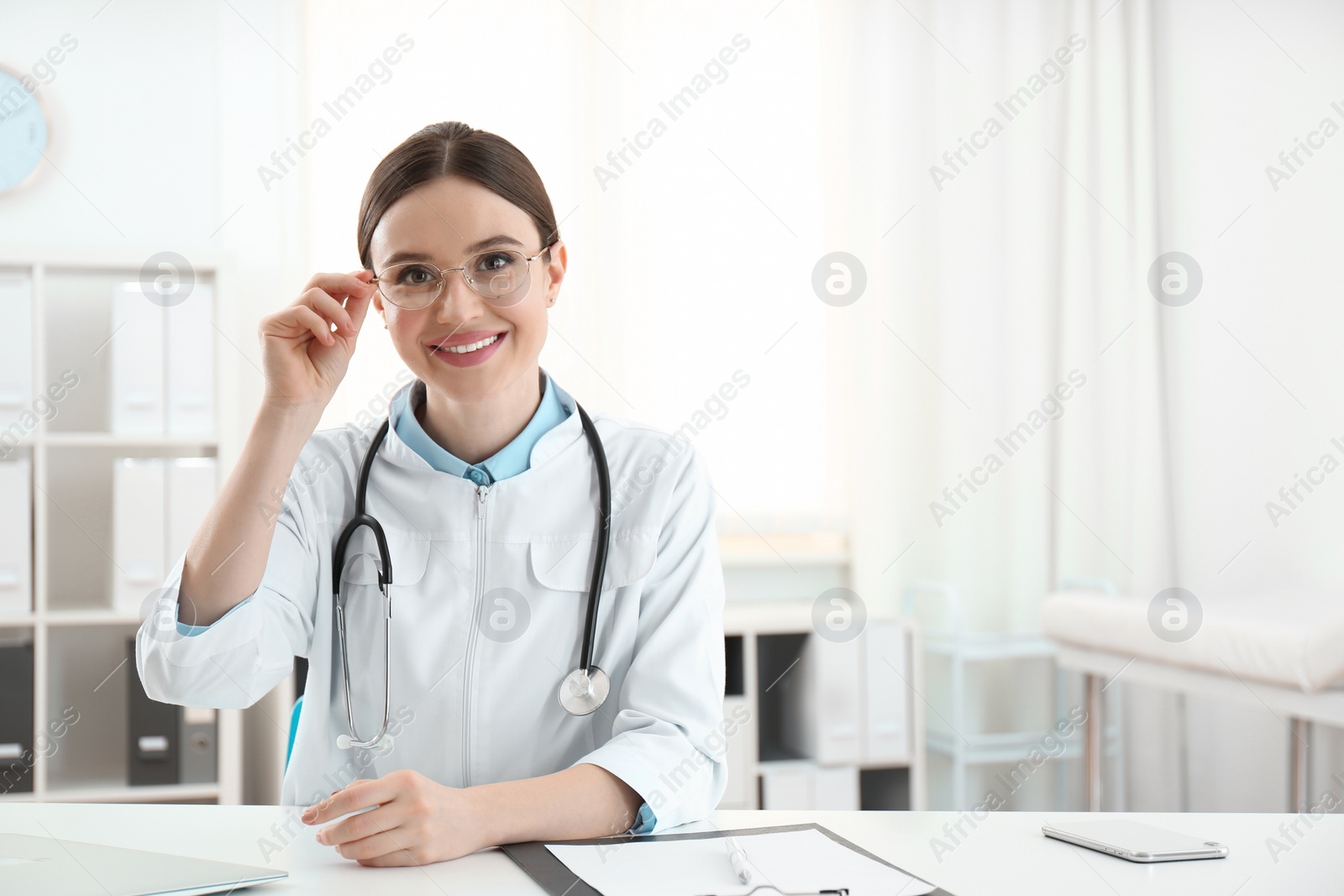 Photo of Portrait of young female doctor in white coat at workplace