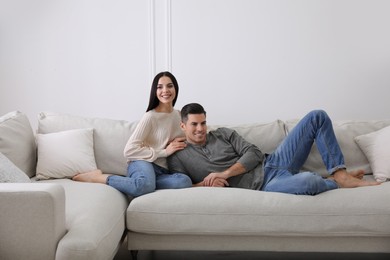 Photo of Couple resting on sofa in living room