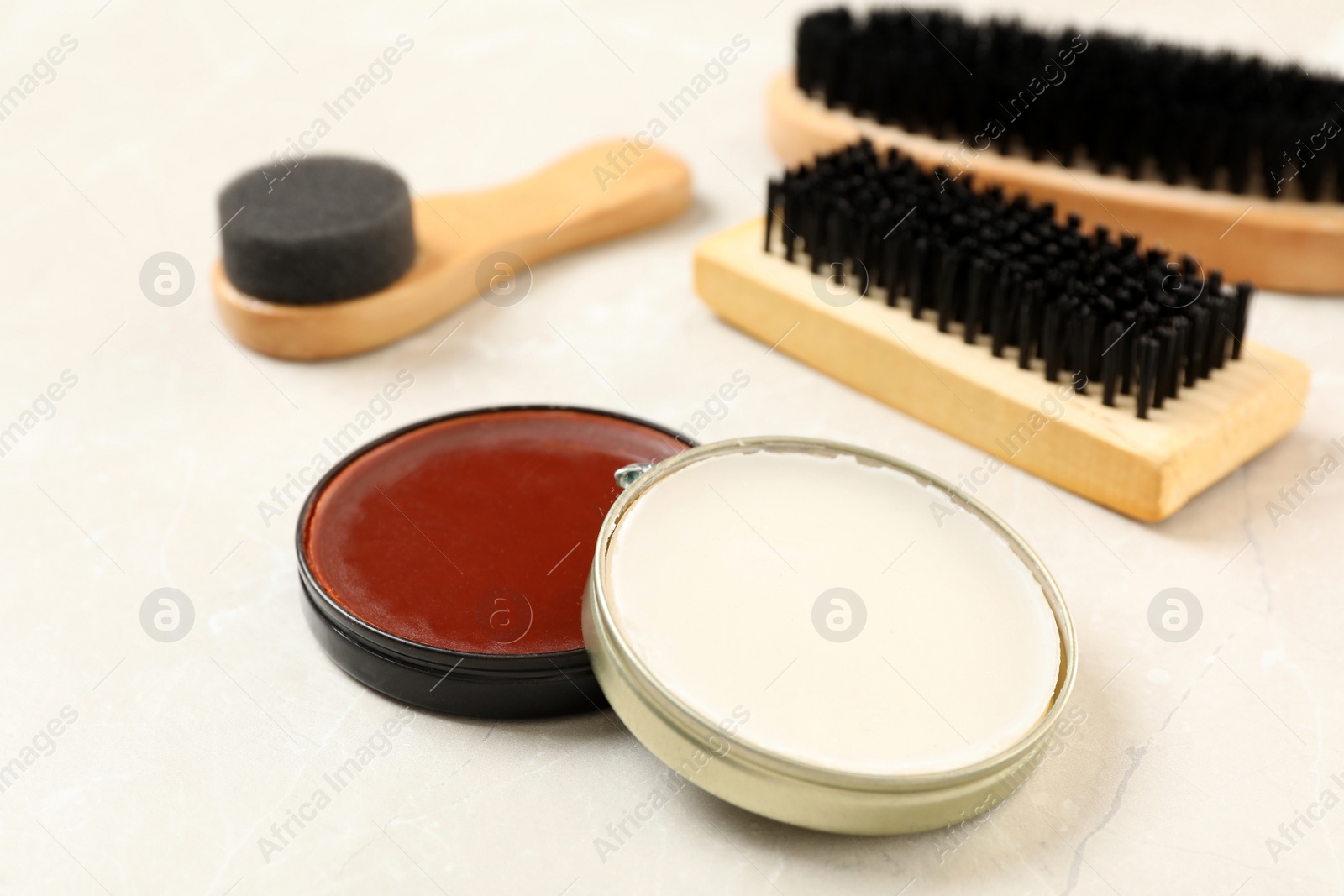 Photo of Composition with shoe care accessories on light marble background, closeup