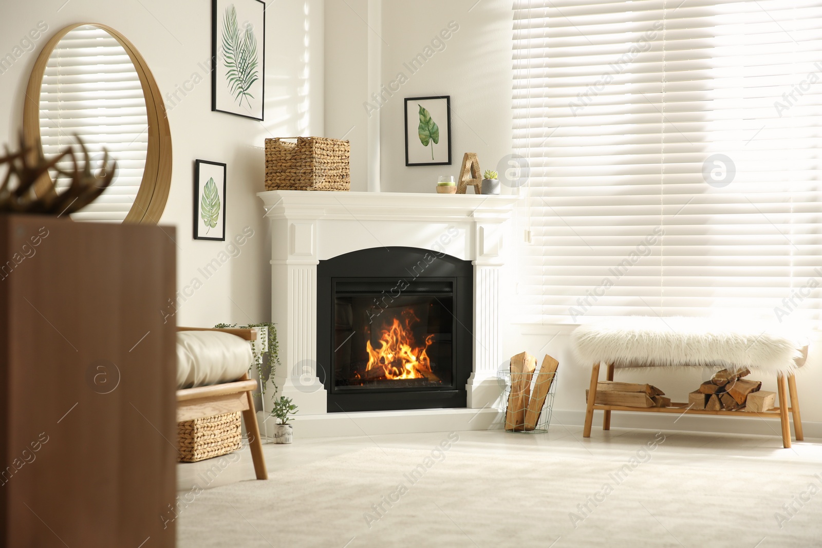 Photo of Bright living room interior with artificial fireplace and firewood