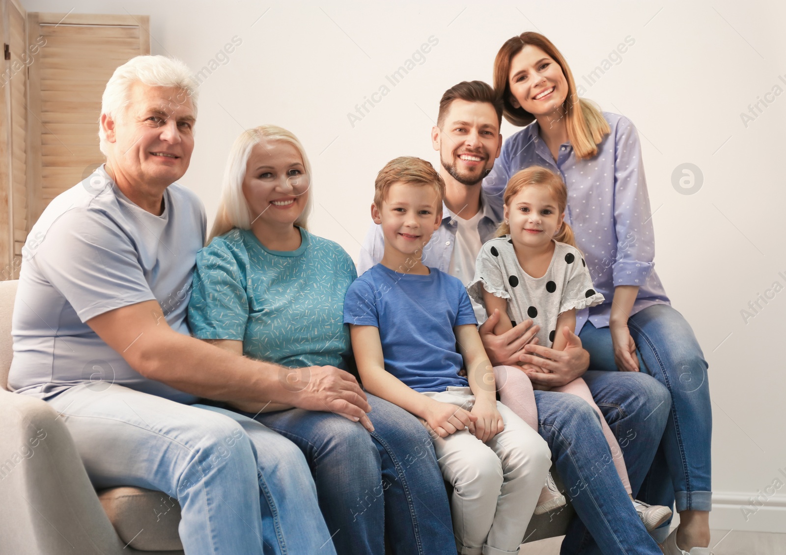 Photo of Happy family with cute kids on sofa at home