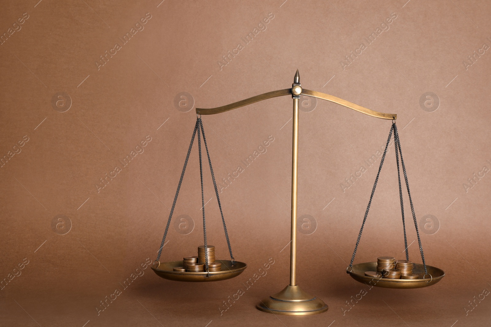 Photo of Scales with stacks of coins on brown background. Harmony and balance concept