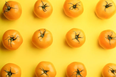 Photo of Yellow tomatoes on color background, flat lay