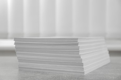 Photo of Stack of paper sheets on grey table, closeup