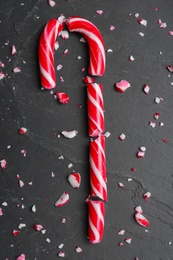 Photo of Crushed Christmas candy cane on black background, flat lay