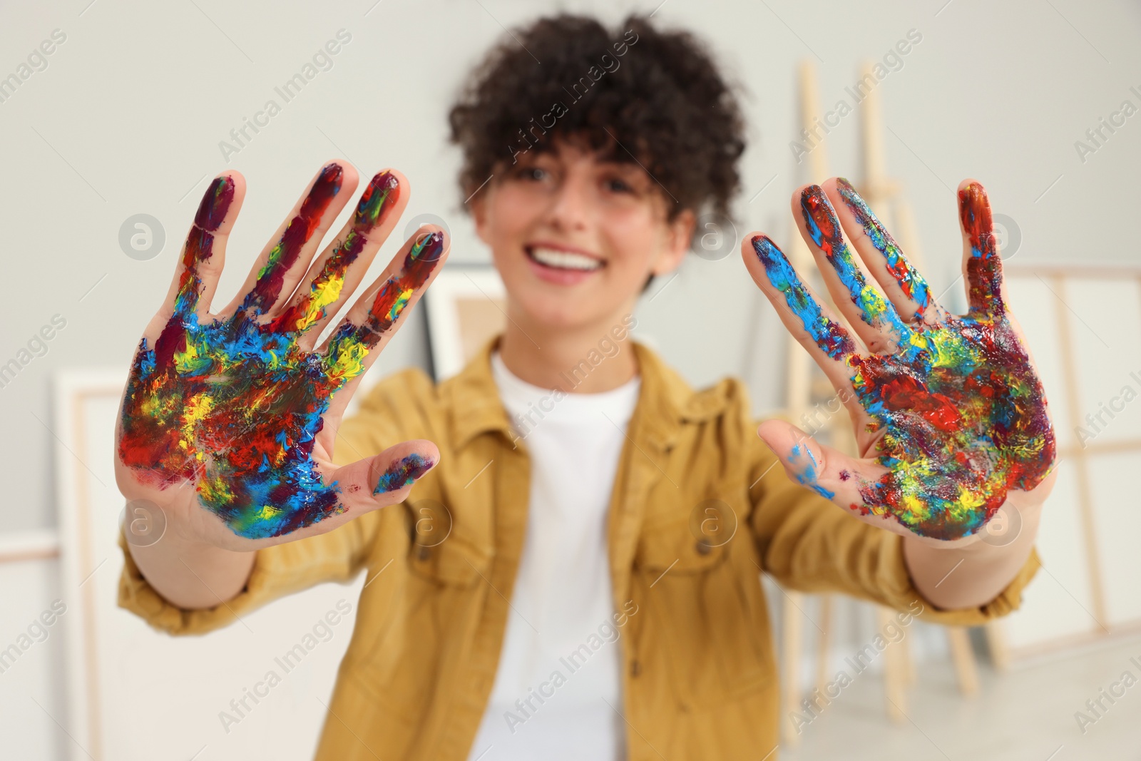 Photo of Young woman with painted palms indoors, selective focus