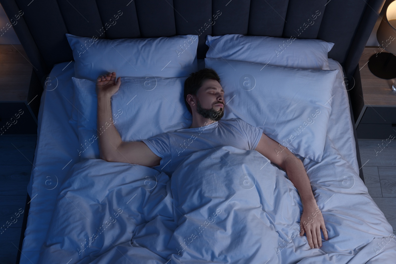 Photo of Man sleeping in bed at night, above view