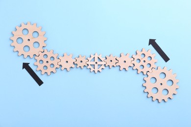 Business process organization and optimization. Scheme with wooden figures and arrows on light blue background, top view