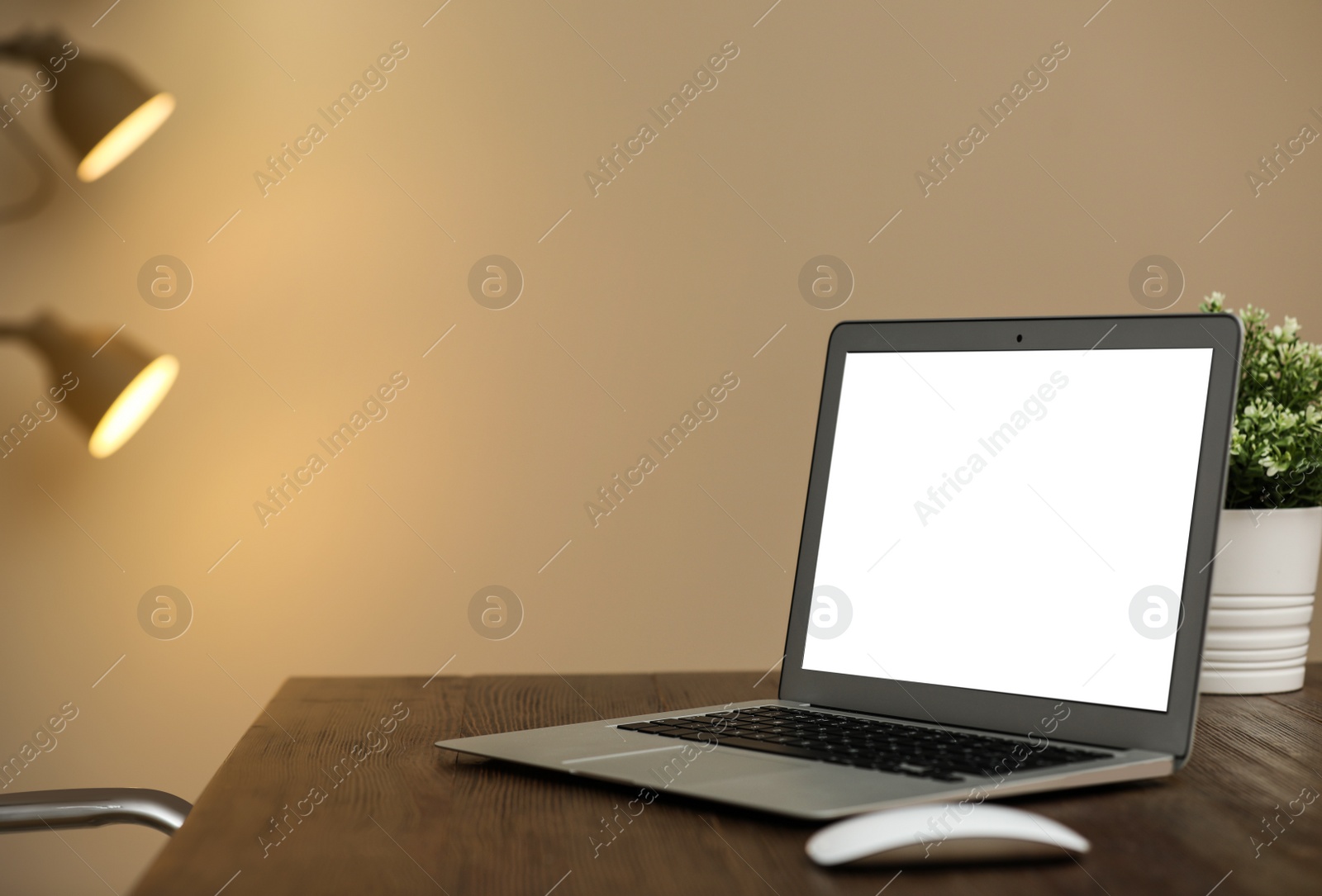 Photo of Laptop with blank screen on table indoors. Space for text