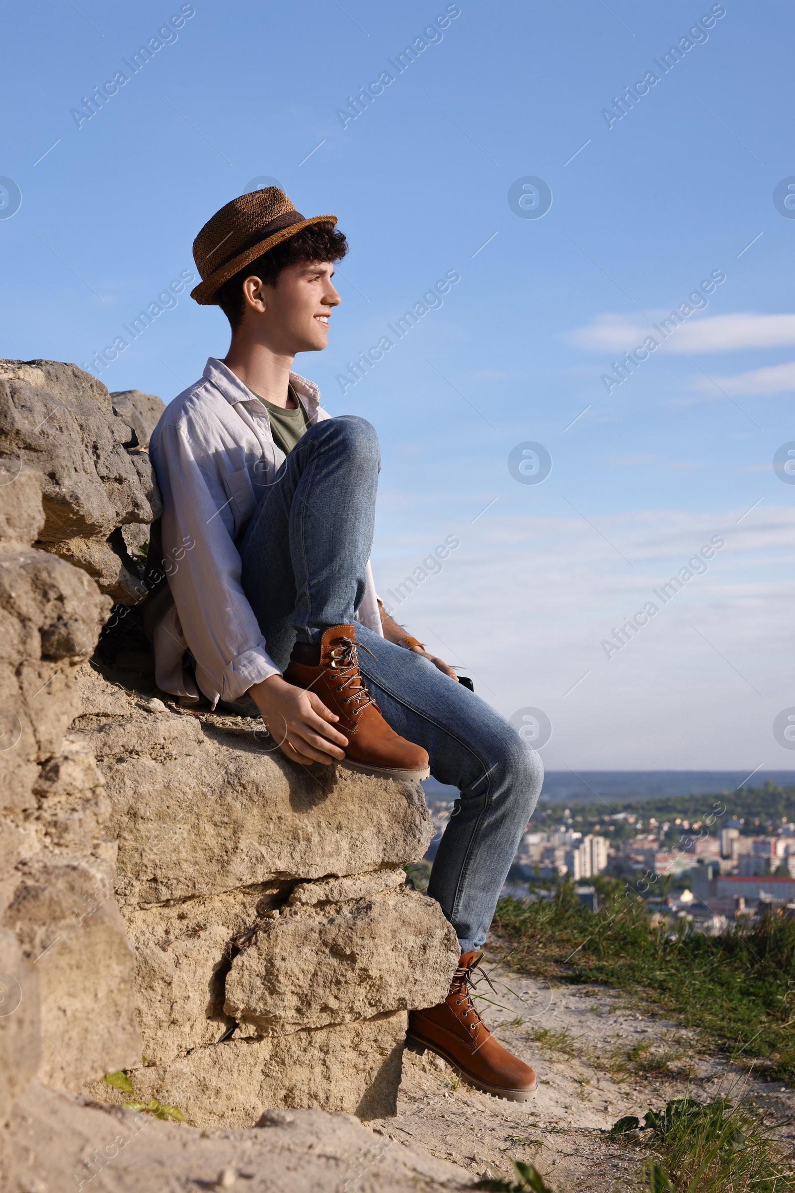 Photo of Travel blogger on stone looking at beautiful view outdoors