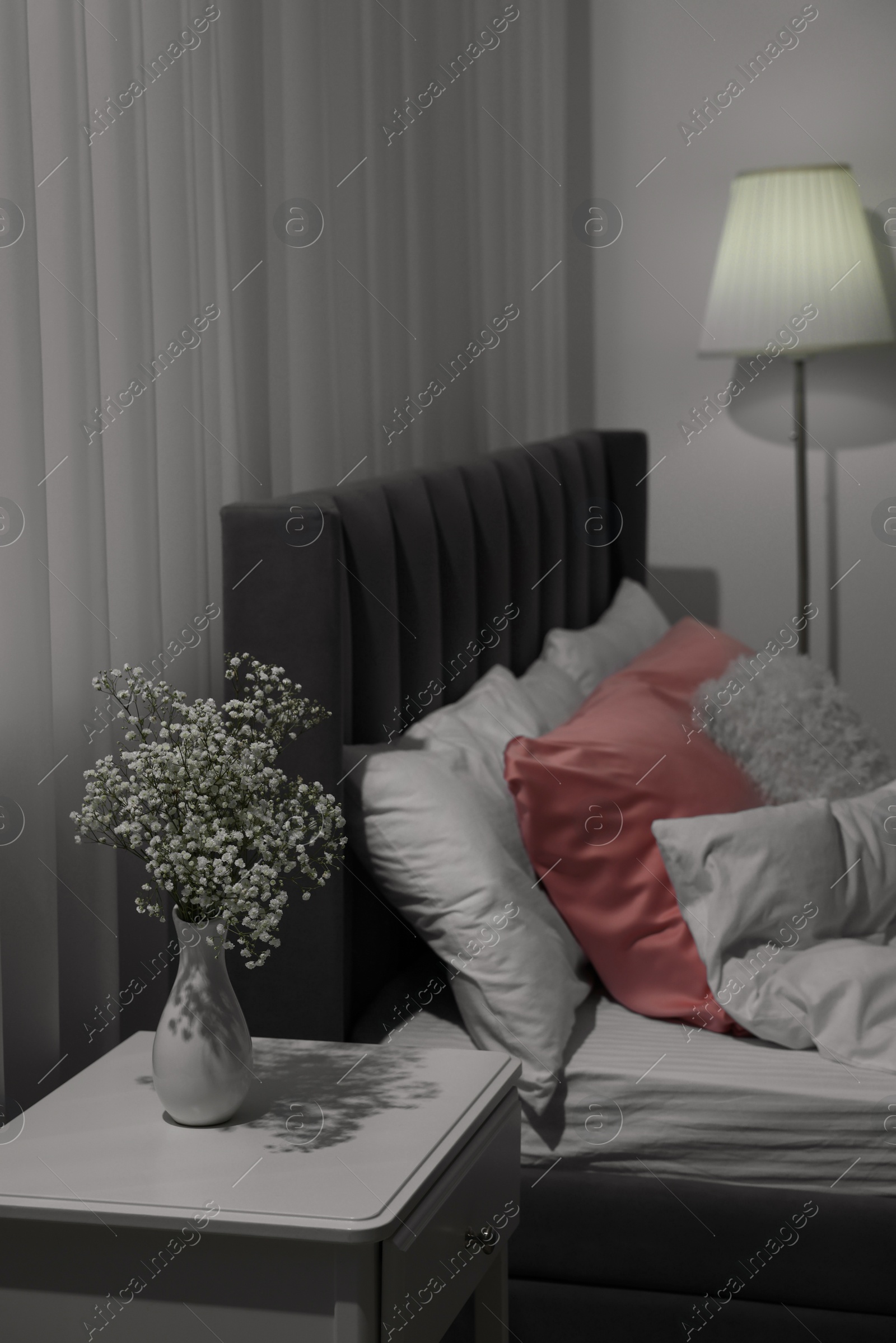 Photo of Stylish bedroom interior with comfortable bed, nightstand and lamp
