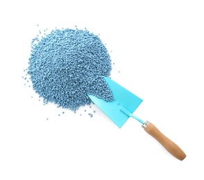 Pile of granular mineral fertilizer and shovel on white background, top view