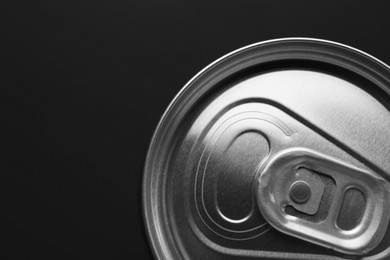 Photo of Energy drink in can on black background, top view. Space for text