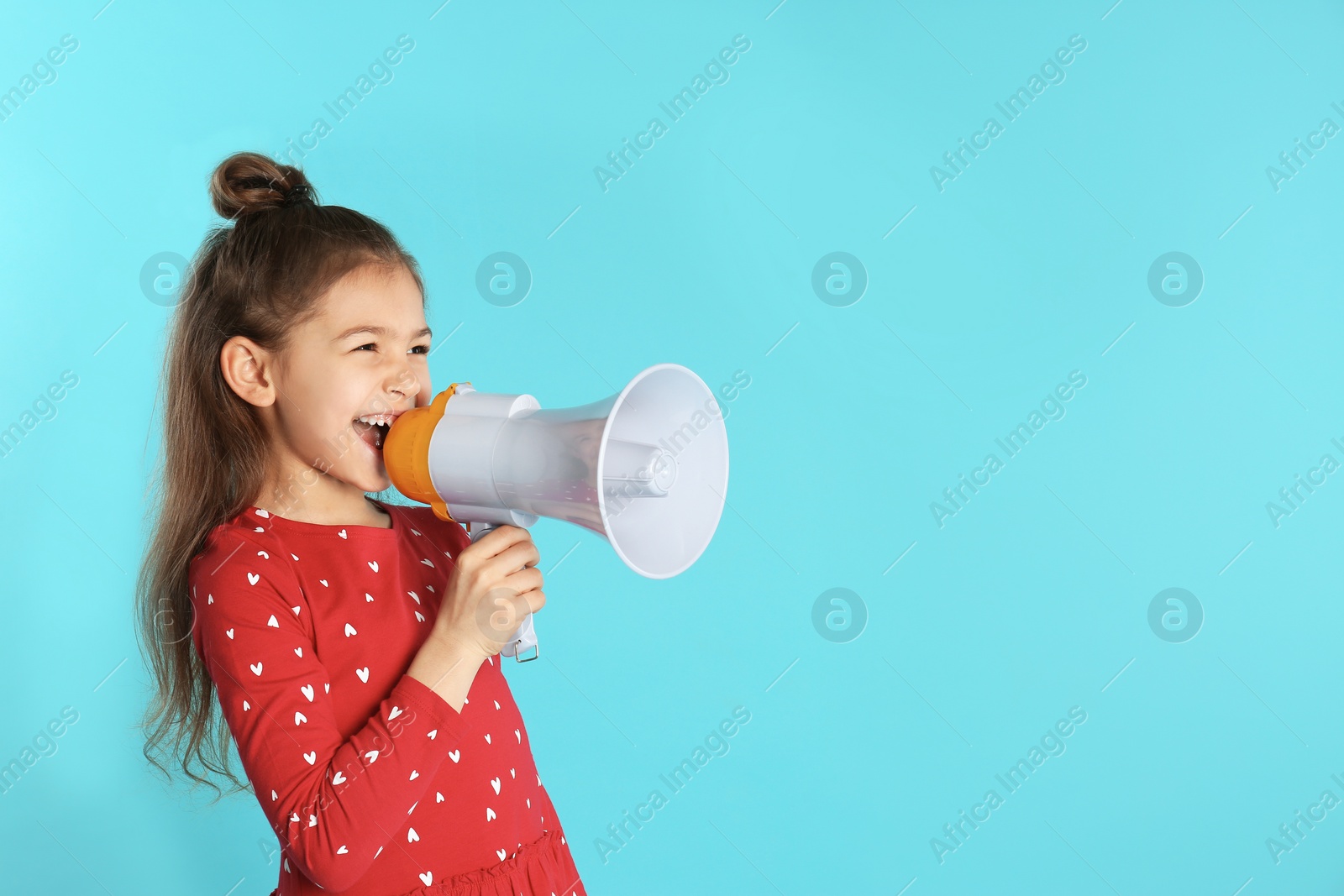 Photo of Cute funny girl with megaphone on color background. Space for text