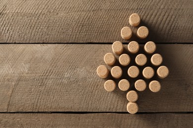 Photo of Christmas tree made of wine corks on wooden table, top view. Space for text