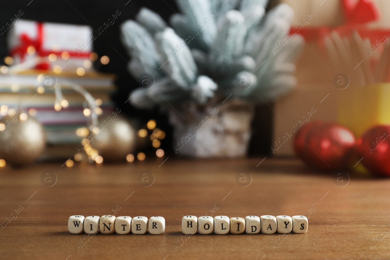 Photo of Cubes with phrase Winter Holidays and blurred Christmas decor on background. Space for text