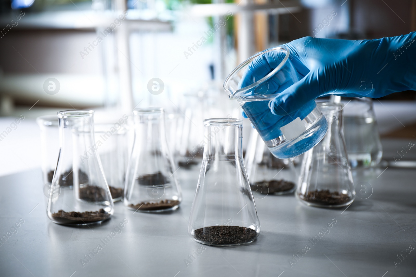 Photo of Scientist preparing soil extract at table, closeup. Laboratory research