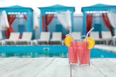 Refreshing cocktails near outdoor swimming pool on sunny day