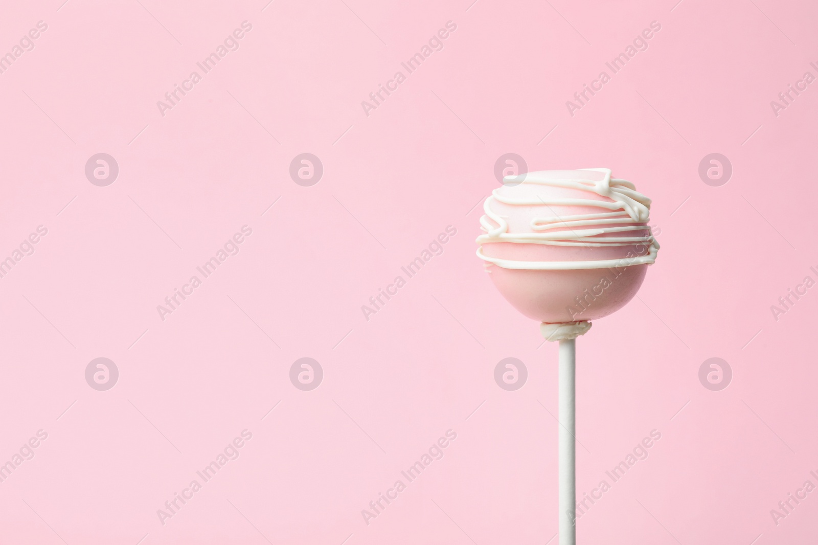 Photo of Sweet decorated cake pop on pink background, space for text