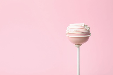 Photo of Sweet decorated cake pop on pink background, space for text