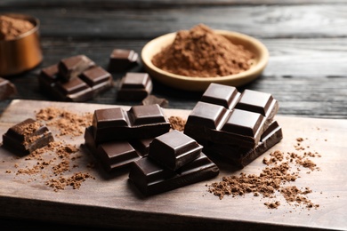 Pieces of black chocolate on wooden board