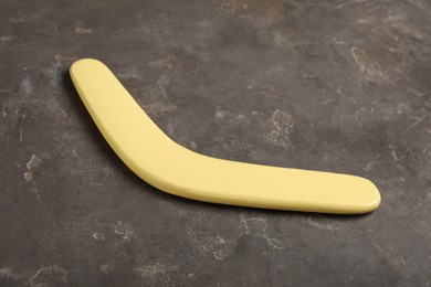 Yellow boomerang on grey stone background. Outdoors activity