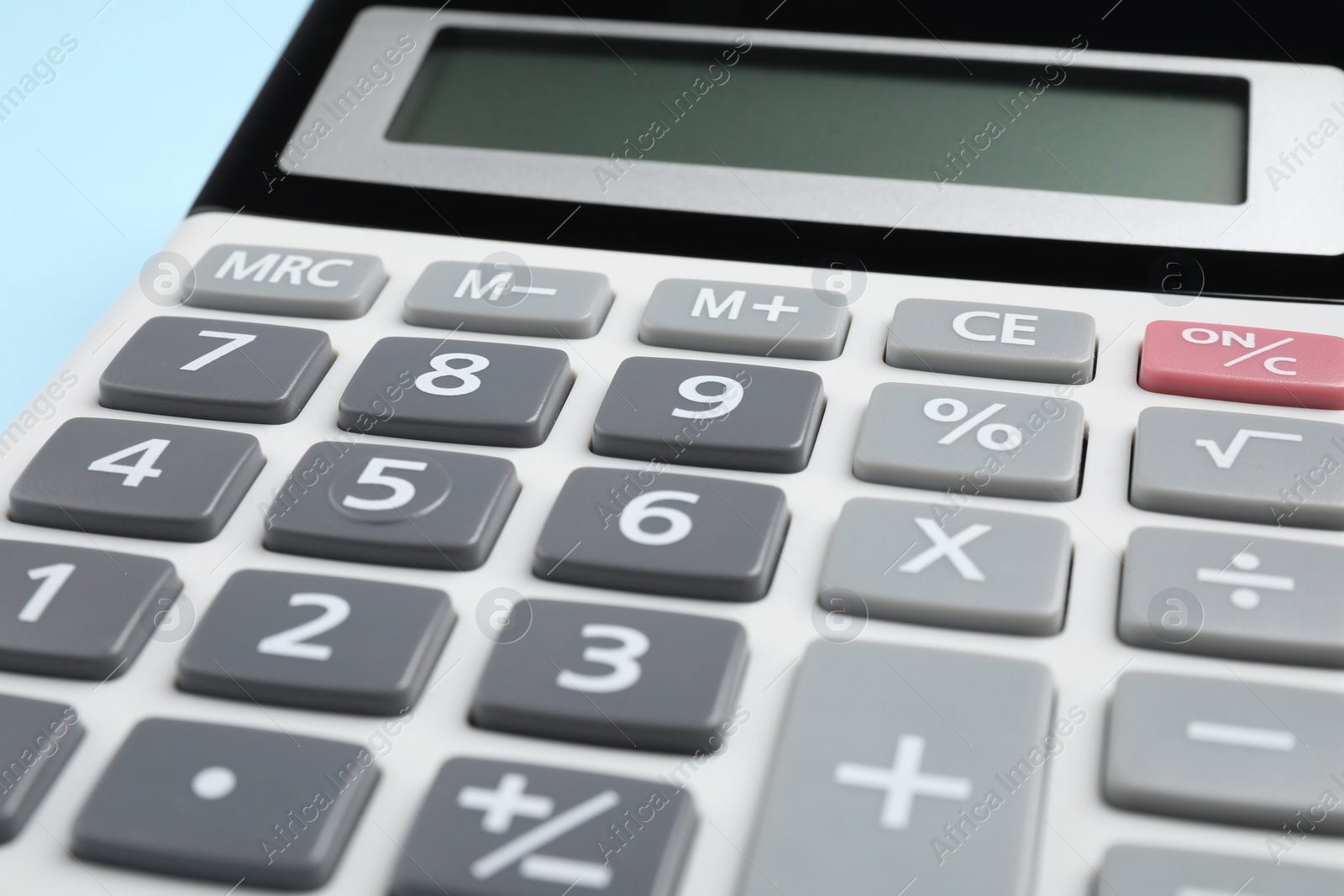 Photo of Calculator on light blue background, closeup. Office stationery