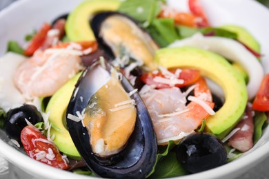 Photo of Bowl of delicious salad with seafood, closeup view