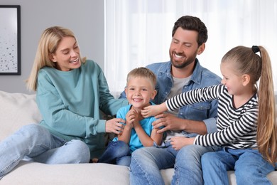 Photo of Happy family having fun together on sofa at home