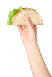 Woman holding delicious taco with meat and vegetables on white background, closeup
