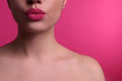 Photo of Closeup view of beautiful woman puckering lips for kiss on pink background
