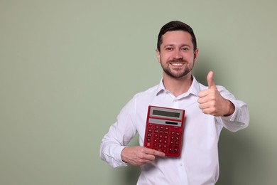 Happy accountant with calculator showing thumb up on olive background. Space for text