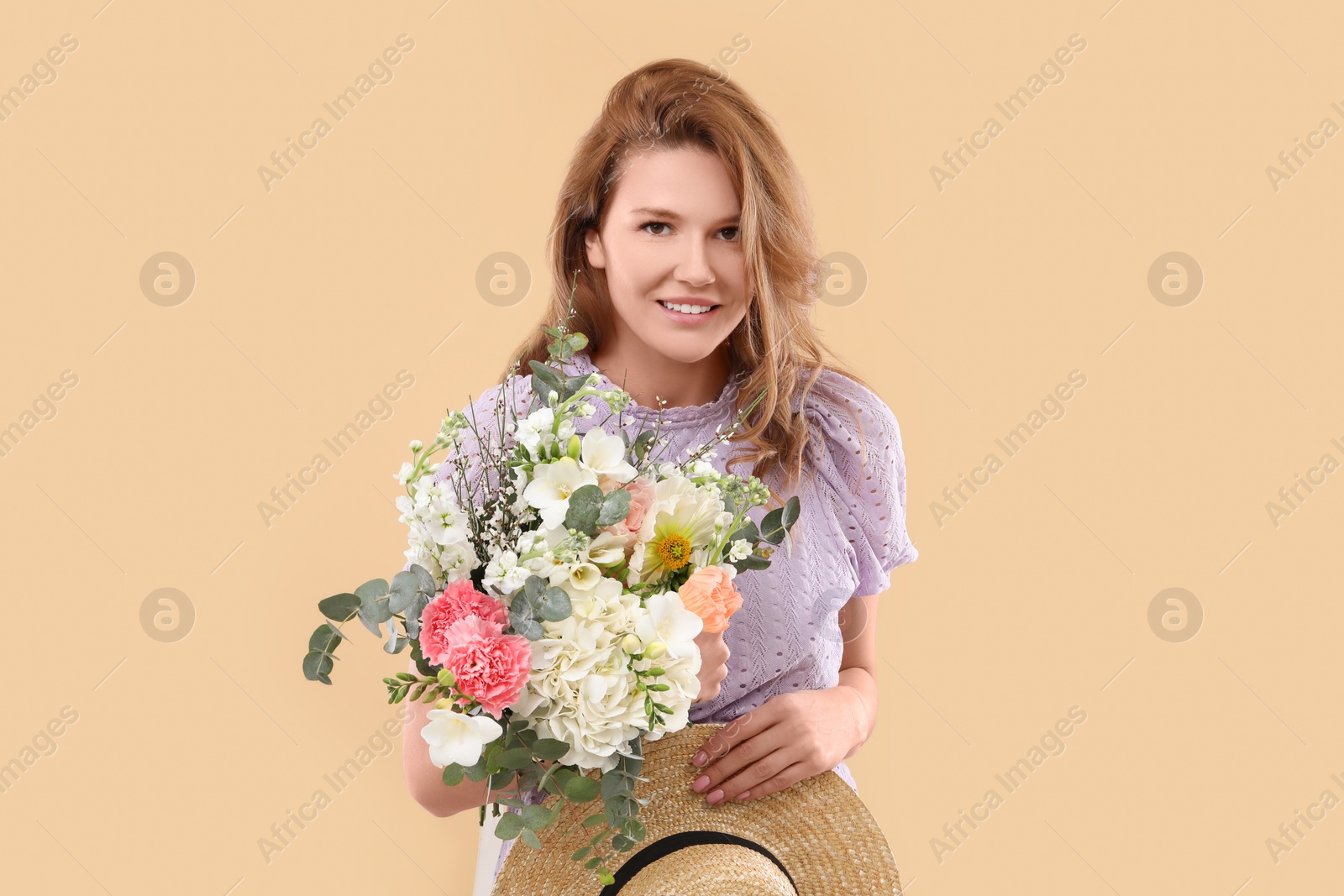 Photo of Beautiful woman with bouquet of flowers on beige background