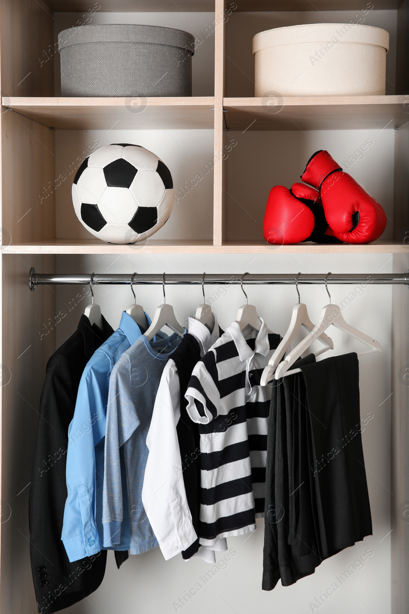 Photo of Wardrobe with stylish boy's clothes hanging on rack