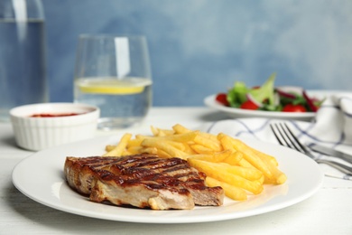 Image of Grilled steak with French fries on white table