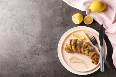 Tasty lemon chicken served on grey table, flat lay. Space for text