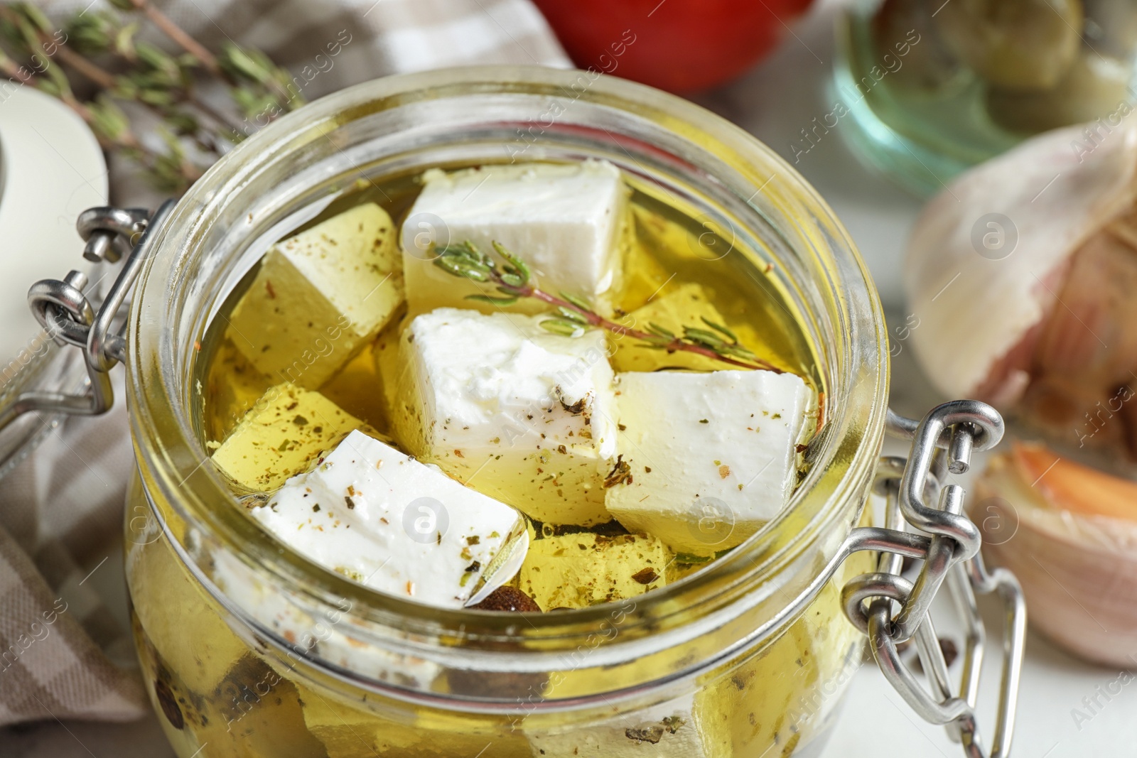 Photo of Composition with pickled feta cheese in jar on table, closeup