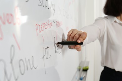 Photo of English teacher giving lesson near whiteboard, closeup