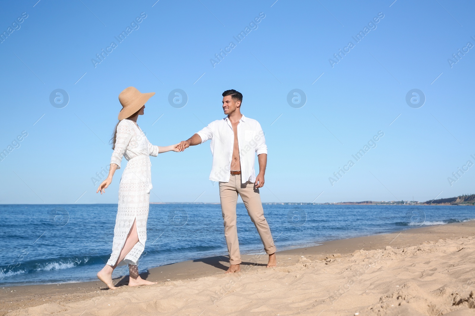 Photo of Lovely couple walking together on sandy beach